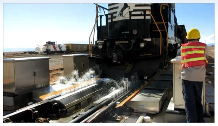 A rail worker looks at a train.